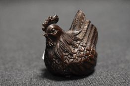 An early 20th century Japanese carved wood Netsuke of a Chicken or Hen