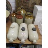 A trio of stone hot water bottles, and a collection of jars and flagons.