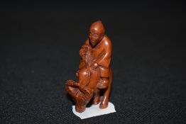 An early 20th century Japanese carved wood Netsuke of a nomad riding an Ox