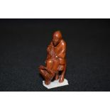 An early 20th century Japanese carved wood Netsuke of a nomad riding an Ox