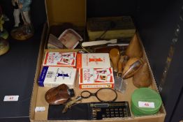 A selection of curios and trinkets including coins and currency, packs of cards and wooden
