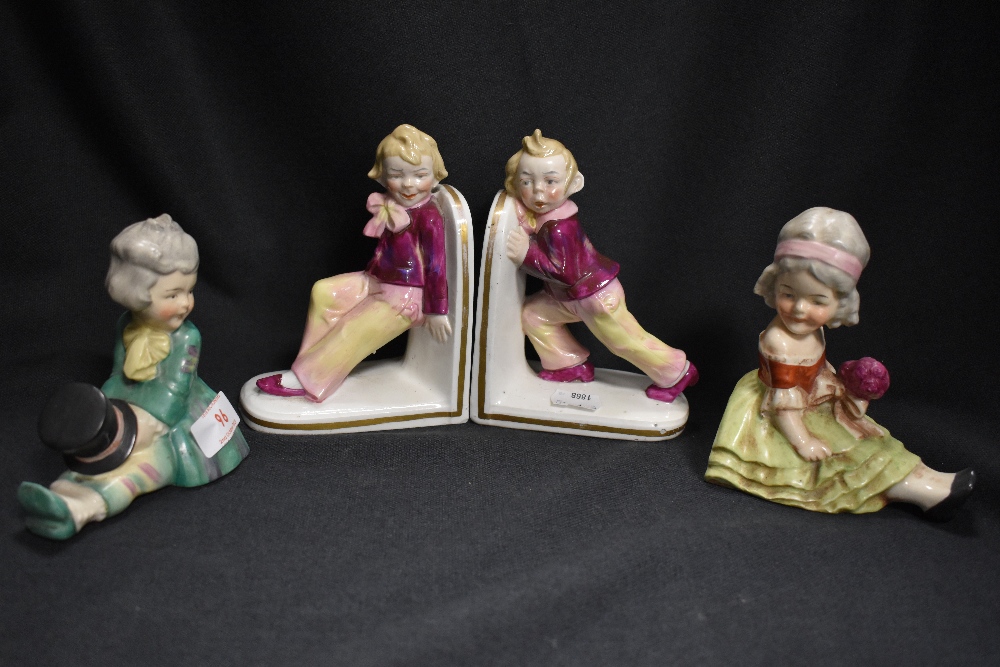 Two sets of Edwardian era ceramic book ends including Dandy styled couple and two boys pushing