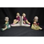 Two sets of Edwardian era ceramic book ends including Dandy styled couple and two boys pushing