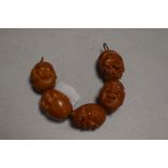 A set of five early 20th century Japanese Ojime carved wood beads of changing heads