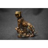 An Oriental brass tiger study, depicted mid roar and climbing a ledge.