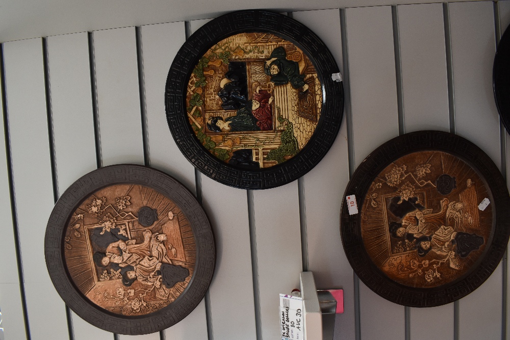 Four mid century oriental style Bretby wall plaques.