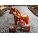 Three graduated mid century Nils Olsson Dala horse figures, tallest figure measures 26cm tall