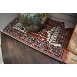 An Oriental fringed rug or prayer mat.