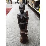 An African ethnic wood figure of a tribal lady with mixing pot