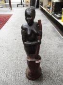 An African ethnic wood figure of a tribal lady with mixing pot