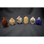 Six vintage Oriental carved snuff bottles, all with intricate detailing, incluing glass and