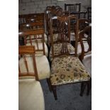 A set of four Edwardian inlaid mahogany dining chairs each with pierced and shaped vase form