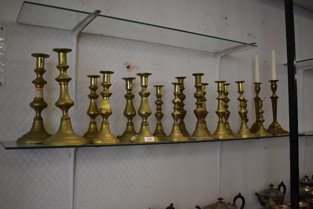 A selection of brass candlesticks. Including 19th century reeded column candlesticks. nine pairs