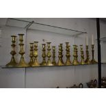 A selection of brass candlesticks. Including 19th century reeded column candlesticks. nine pairs