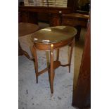 An Edwardian mahogany oval occasional table, raised on slender tapering supports linked by a small