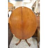 A Victorian mahogany oval loo table with snap top action over bulbous turned stem issuing four