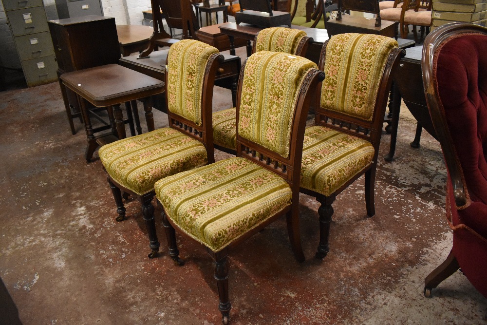A set of four Victorian carved mahogany dining chairs, each upholstered in foliate patterned and