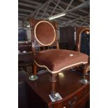 A Victorian mahogany bedroom chair, the back with circular upholstered section between shaped and