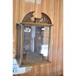 A mahogany 'clock hood' display cabinet, with arched 'broken' pediment over the glazed panels and