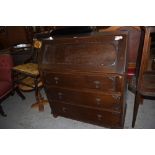 A 1940s oak bureau of traditional design, sold together with an Edwardian inlaid chair, modern