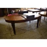 An Edwardian oval mahogany extending dining table, the top with moulded edge detail, raised on