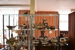 Two shelves of silver plated wares to include tea sets, goblets, baskets and tankards.