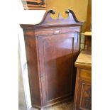 A George III oak corner cupboard with swan neck pediment and single panelled door between canted