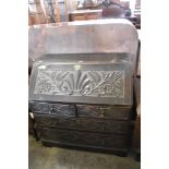 A Victorian carved and stained oak Bureau, of traditional arrangement, carved throughout with