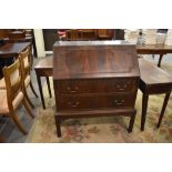 An early 20th century figured mahogany bureau with moulded geometric decoration, the fall front over