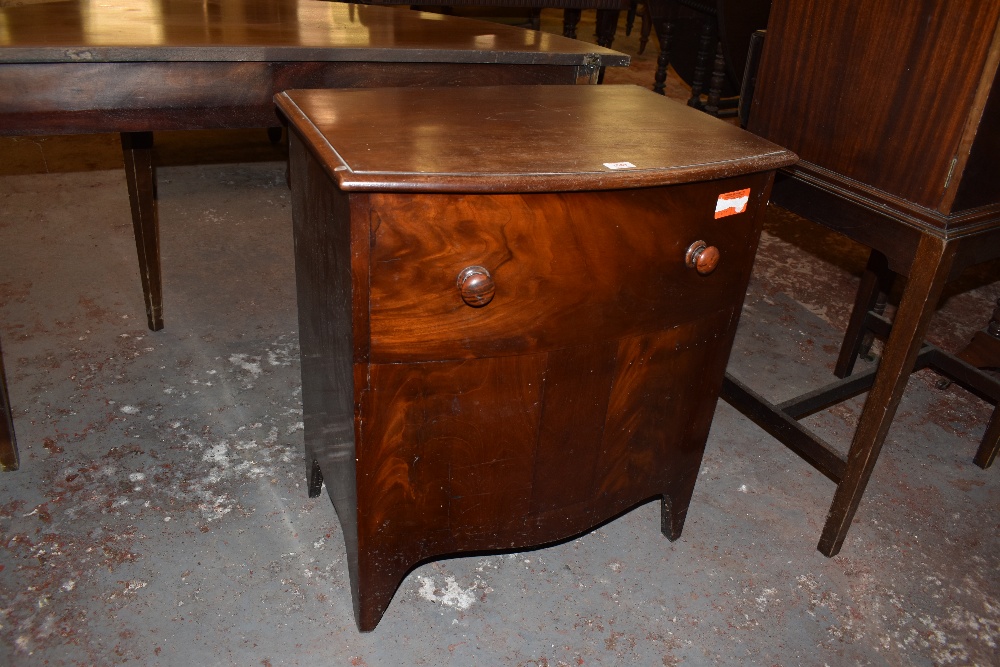 A 19th century mahogany chest form commode, the bow fronted top lifting to reveal the now vacant