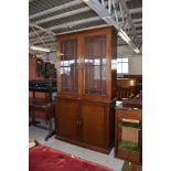 A 20th century glazed mahogany bookcase over cupboard, 215CM. X. 120CM.