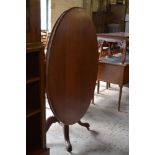 A Victorian mahogany oval loo table with snap top action turned column and for downswept carved