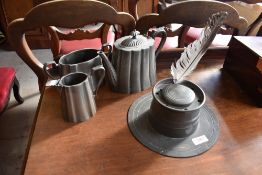 A 19th century pewter Capstan inkwell, and a pewter three piece tea set.