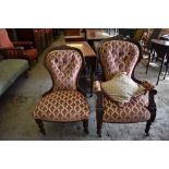 A pair of late Victorian carved mahogany his and hers easy chairs, with deep buttoned backs