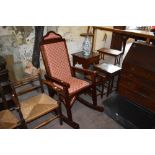 A large 20th century mahogany upholstered rocking chair, having studded construction. Seat height 64
