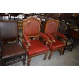 A pair of Victorian light oak armchairs upholstered in stained and studded leather, the arms with