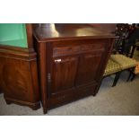 An Edwardian mahogany cupboard, the large door with rosette carved and nulled upper panel over two