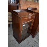 An Edwardian stained mahogany glazed music cabinet with shallow three quarter gallery over the
