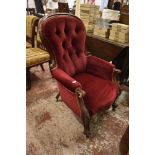 A Victorian deep buttoned spoon back easychair. with scrolling frame and burgundy upholstery. Seat