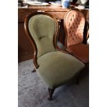 A late Victorian mahogany spoon back nursing chair, upholstered in light green Dralon and raised