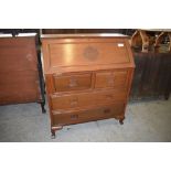 A 20th century Chinese hardwood bureau of traditional arrangement with carved roundel decoration and