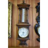 A Victorian carved oak barometer, having an architectural pediment with central urn form finial over