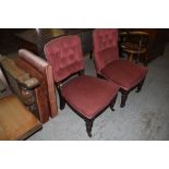 Two Victorian mahogany upholstered salon chairs, having deep buttoned backs, raised on turned and