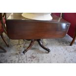 A Victorian mahogany pedestal Pembroke table, of oblong form with rounded flaps, raised on turned