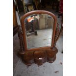 A Victorian mahogany swing dressing mirror with arched and bevelled mirror over turned supports