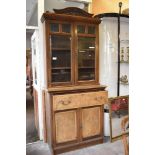 A late Victorian walnut secretaire bookcase, having stippled carved surmount and bevelled glazed