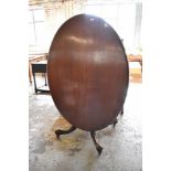 A Victorian mahogany oval snap top loo table, the top raised on four turned and fluted supports