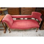 A late Victorian walnut framed chaise longue, with scrolled padded arm, carved and pierced