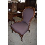 A Victorian mahogany spoon back nursing chair, the padded and scrolled spoon back over a