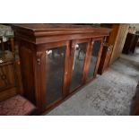 A large Victorian glazed mahogany bookcase top, having a moulded cornice over carved pendant and